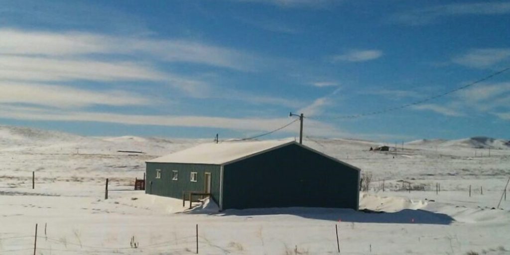 kleines Haus mit schneebedecktem flachen Dach im eiskalten Winter